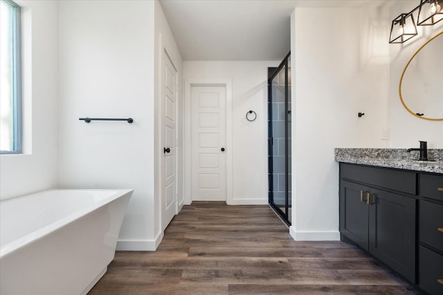 bathroom featuring wood-type flooring, shower with separate bathtub, and vanity