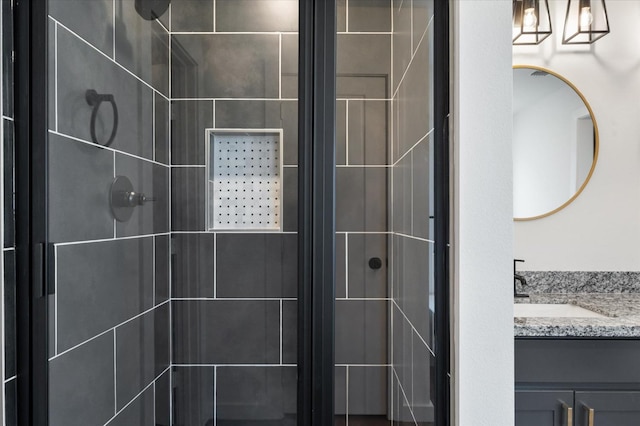 bathroom with vanity and a tile shower