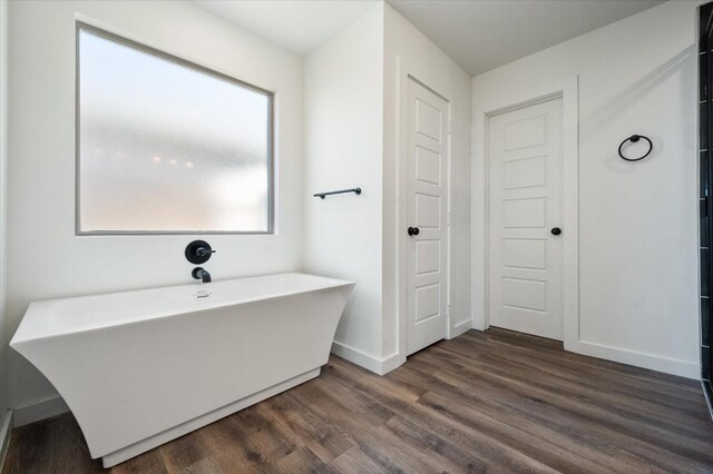 bathroom with hardwood / wood-style flooring and a bathtub