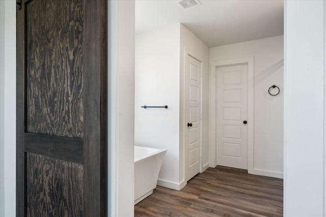 corridor featuring dark hardwood / wood-style flooring and a barn door