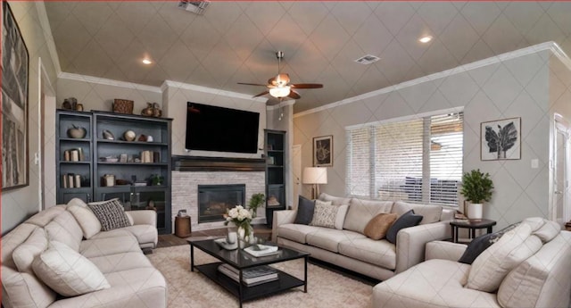 living room featuring crown molding, a stone fireplace, and ceiling fan