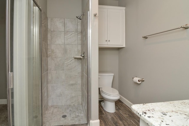 bathroom featuring an enclosed shower, hardwood / wood-style floors, and toilet