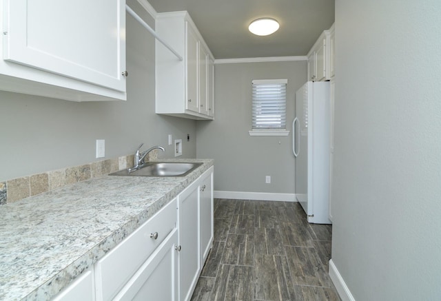 kitchen with dark hardwood / wood-style flooring, sink, white cabinets, and white refrigerator