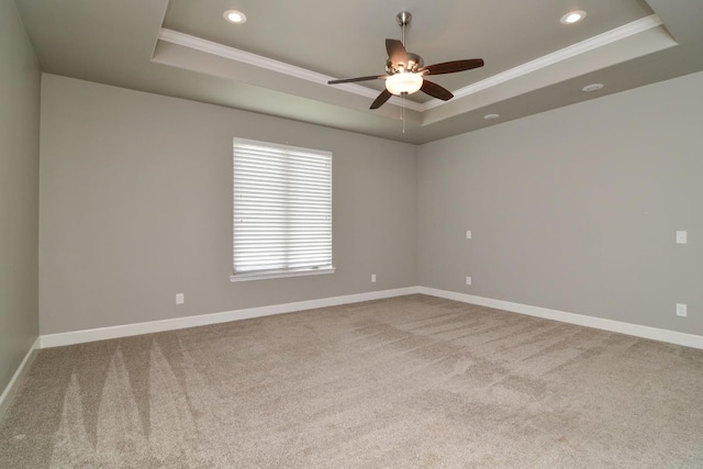 carpeted spare room with crown molding, a raised ceiling, and ceiling fan