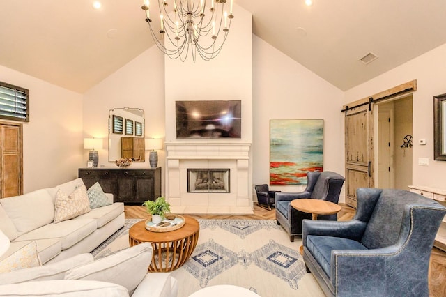 living room with a barn door, high vaulted ceiling, and an inviting chandelier