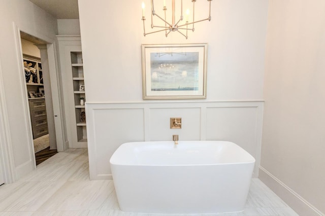 bathroom with a tub and a chandelier