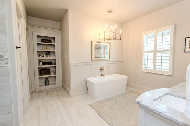 bathroom with vanity, a chandelier, and a washtub