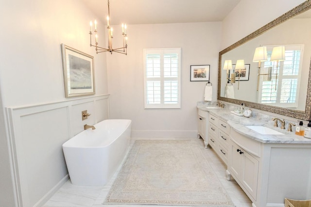 bathroom with vanity, a bath, and a chandelier