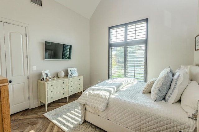 bedroom featuring dark parquet flooring and vaulted ceiling