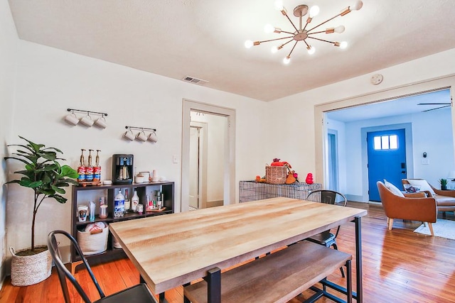 dining room with hardwood / wood-style flooring and an inviting chandelier