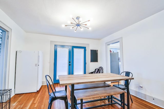 dining area with a chandelier and light wood-type flooring