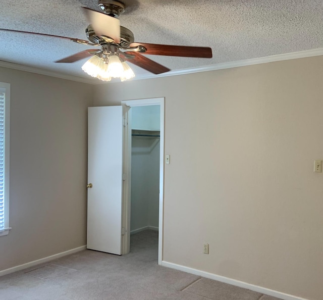 unfurnished bedroom featuring light carpet, a spacious closet, and ornamental molding