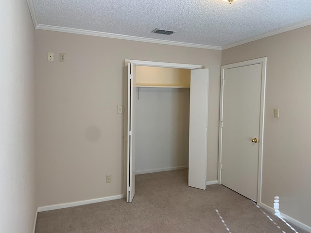 unfurnished bedroom with crown molding, light carpet, a closet, and a textured ceiling