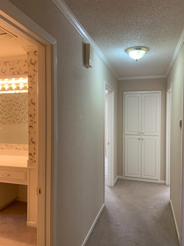 corridor featuring light carpet, ornamental molding, and a textured ceiling