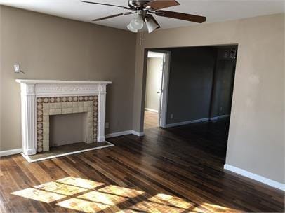 unfurnished living room featuring dark hardwood / wood-style flooring, a fireplace, and ceiling fan