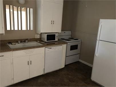 kitchen with sink, white appliances, and white cabinets