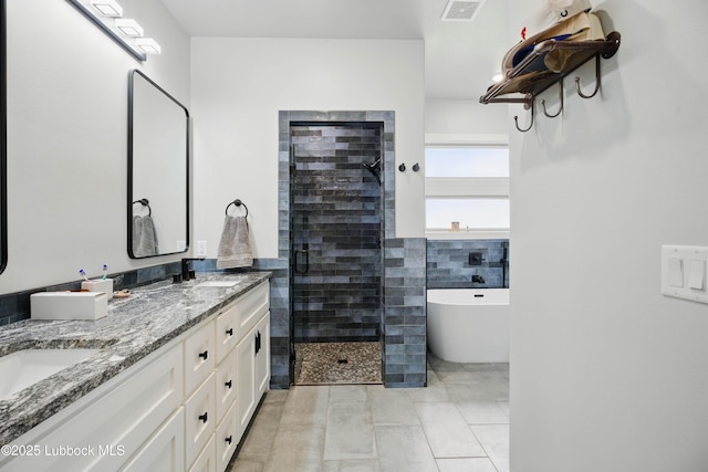 13803 Quinton Ave, Lubbock, TX 79424 - full bath featuring a shower stall, a freestanding bath, double vanity, and tile patterned flooring