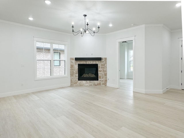 unfurnished living room with crown molding, a chandelier, a fireplace, and light hardwood / wood-style flooring