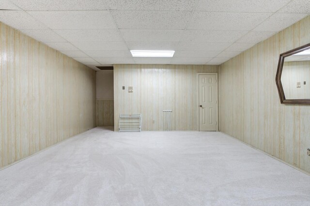 interior space with a paneled ceiling and carpet flooring