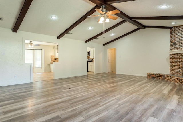 unfurnished living room featuring a fireplace, vaulted ceiling with beams, ceiling fan, light hardwood / wood-style floors, and a textured ceiling