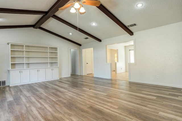 unfurnished living room with lofted ceiling with beams, ceiling fan, a textured ceiling, and light wood-type flooring