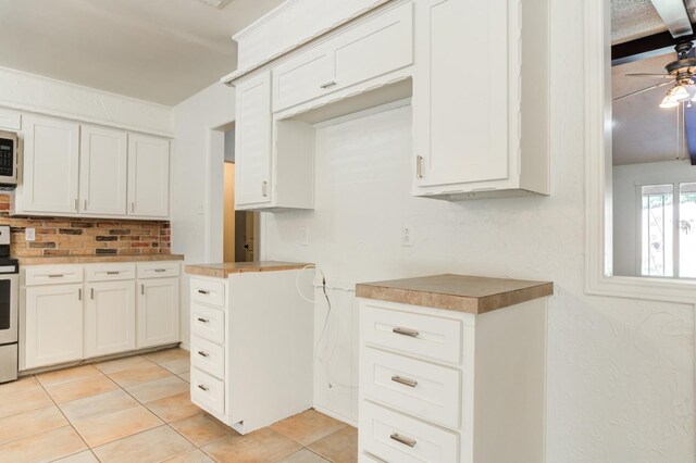 kitchen with white cabinetry, light tile patterned floors, stainless steel appliances, and ceiling fan