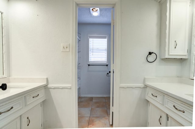 bathroom featuring vanity, tile patterned flooring, and a textured ceiling