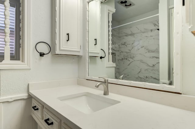 bathroom featuring vanity and tiled shower