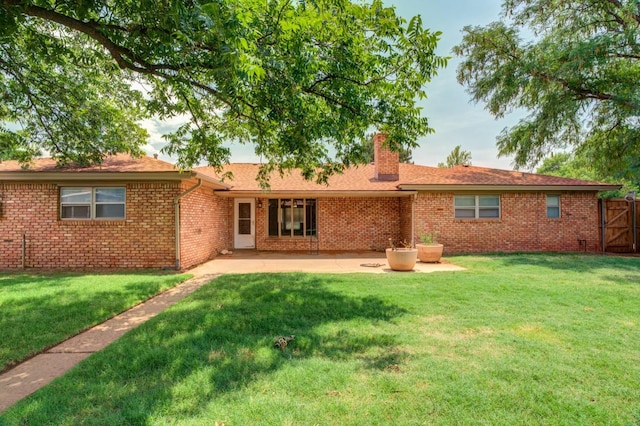 back of property featuring a patio and a lawn