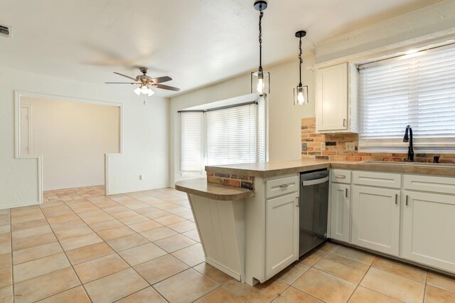 kitchen featuring sink, white cabinetry, decorative light fixtures, stainless steel dishwasher, and kitchen peninsula