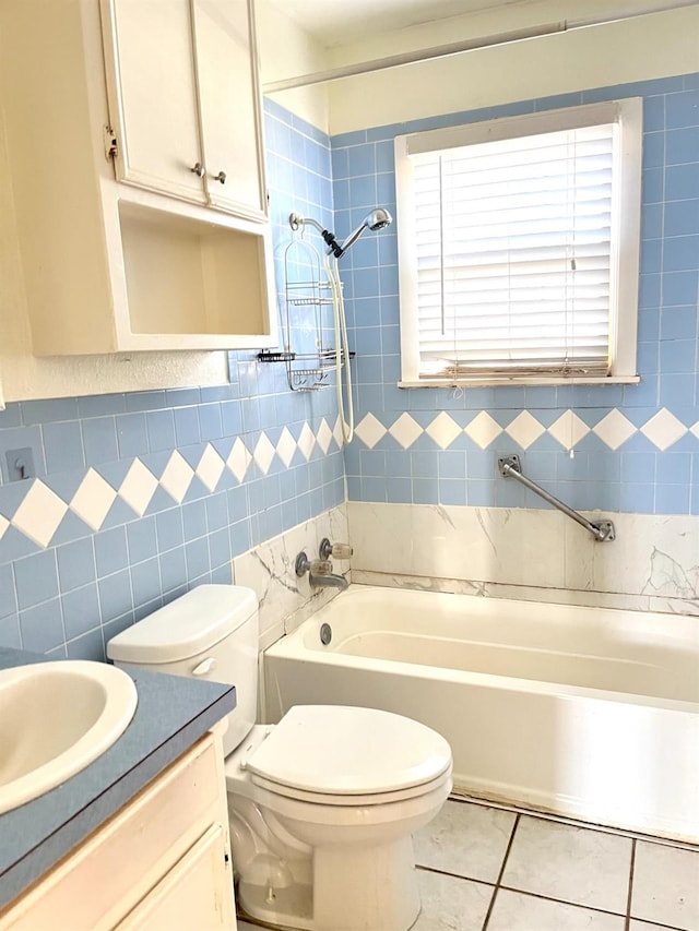 full bathroom with tiled shower / bath, toilet, tile patterned flooring, and tile walls