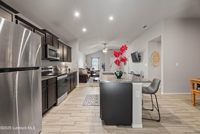 6827 38th St, Lubbock, TX 79407 - kitchen featuring appliances with stainless steel finishes, ceiling fan, a kitchen breakfast bar, a kitchen island with sink, and light wood finished floors