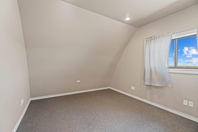 additional living space featuring lofted ceiling and carpet flooring