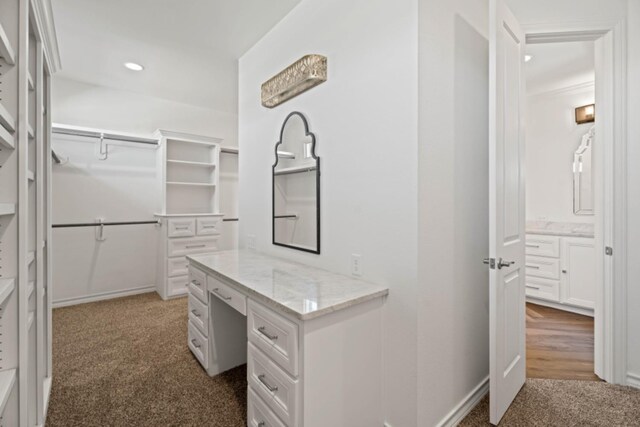 spacious closet with dark colored carpet