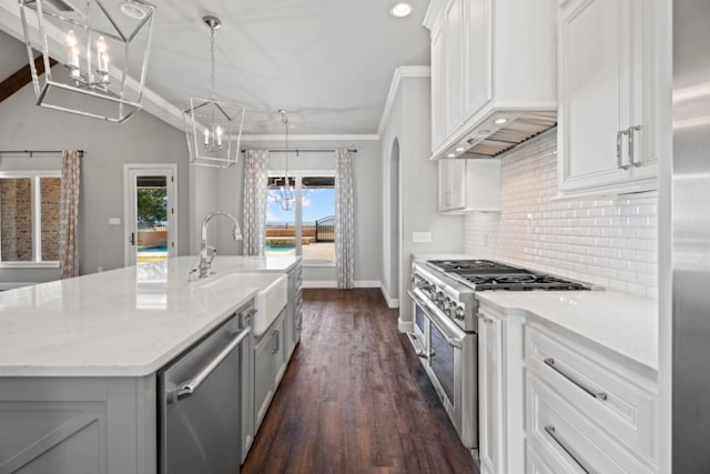 kitchen featuring sink, premium range hood, appliances with stainless steel finishes, an island with sink, and white cabinets