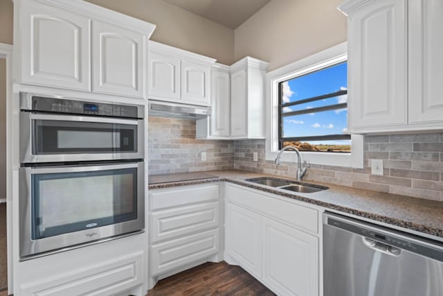 kitchen with sink, decorative backsplash, white cabinets, and appliances with stainless steel finishes