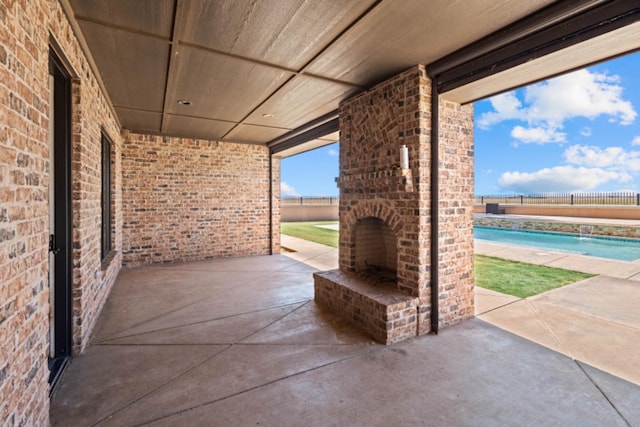 view of patio featuring an outdoor brick fireplace and a fenced in pool