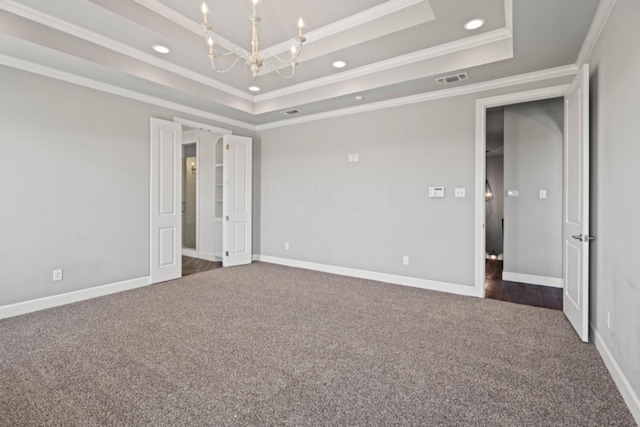 unfurnished bedroom featuring a chandelier, crown molding, a raised ceiling, and dark colored carpet