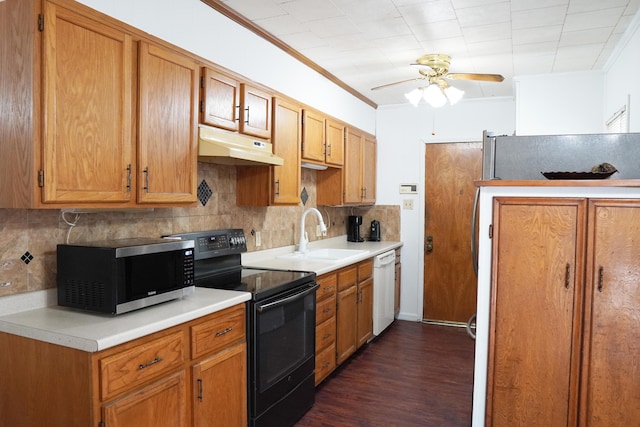 2007 25th St, Lubbock, TX 79411 - kitchen featuring black electric range, under cabinet range hood, stainless steel microwave, a sink, and backsplash
