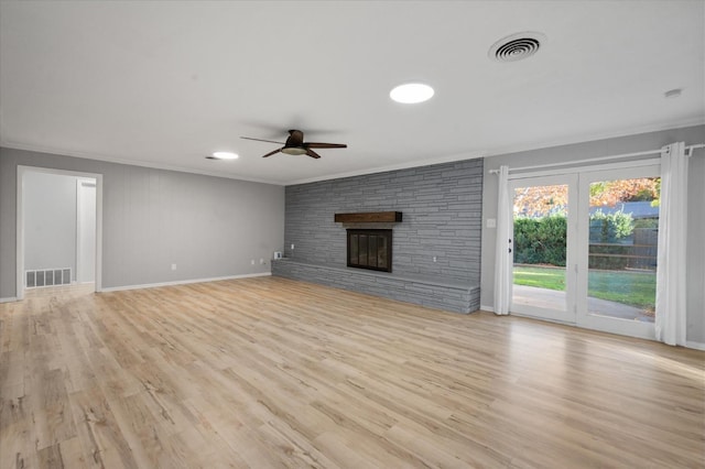 unfurnished living room featuring crown molding, a large fireplace, ceiling fan, and light hardwood / wood-style floors