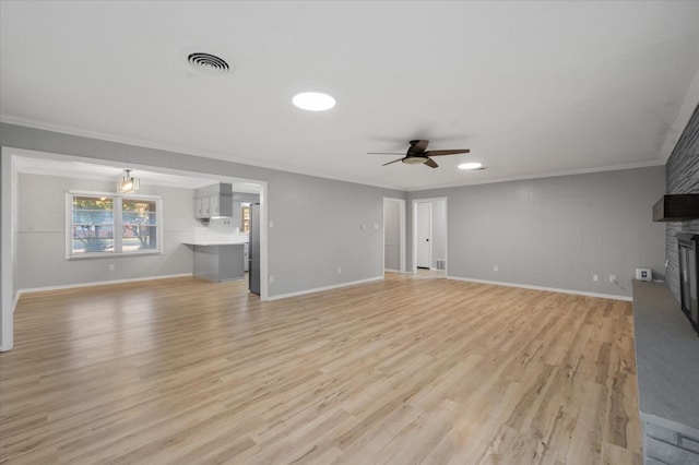 unfurnished living room with crown molding, a fireplace, light hardwood / wood-style floors, and ceiling fan