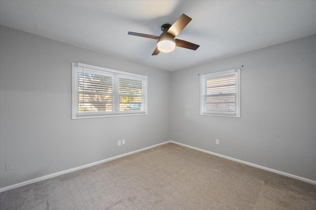 carpeted spare room featuring ceiling fan