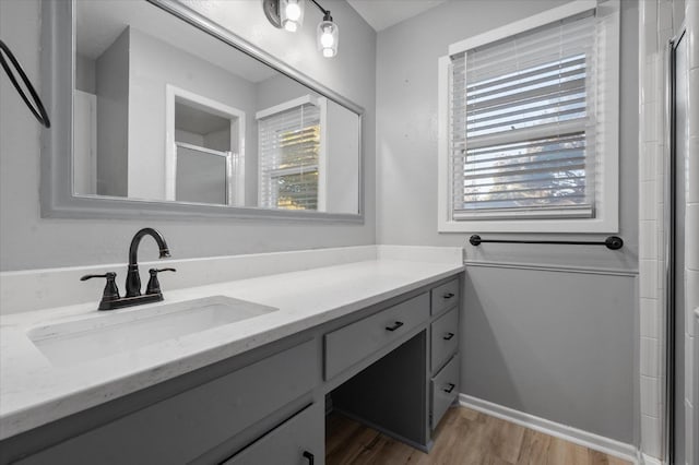 bathroom featuring vanity, wood-type flooring, and walk in shower