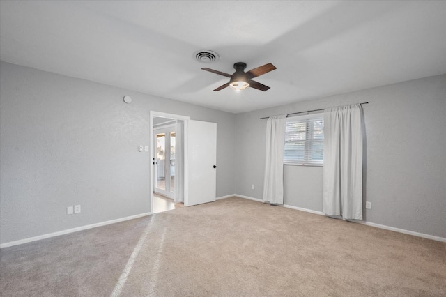 spare room featuring light carpet and ceiling fan