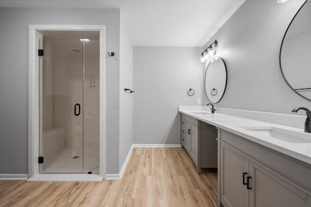 bathroom featuring vanity, an enclosed shower, and wood-type flooring