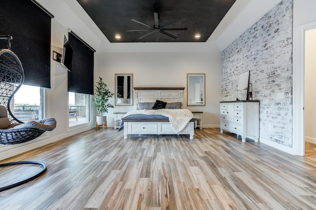 bedroom featuring a towering ceiling and light hardwood / wood-style floors