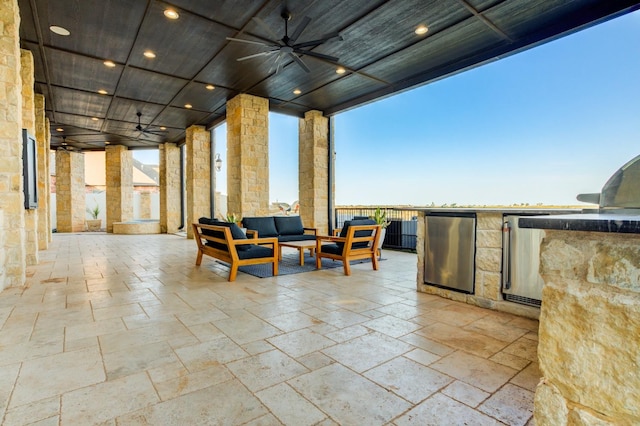 view of patio featuring ceiling fan, an outdoor kitchen, an outdoor living space, and electric panel