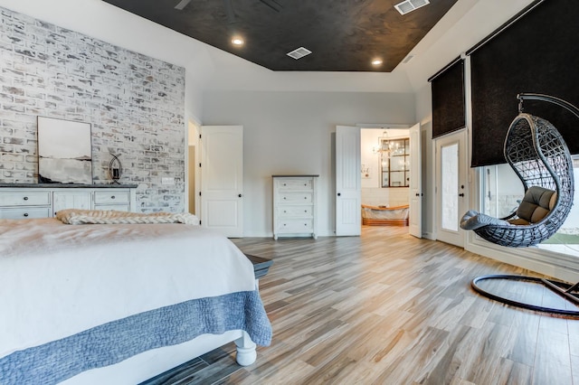 bedroom featuring light hardwood / wood-style floors and a high ceiling