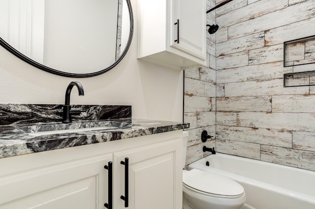 full bathroom featuring tiled shower / bath, vanity, and toilet