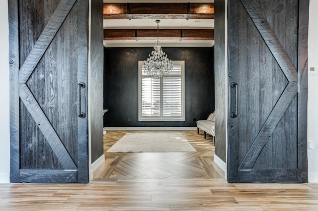 interior space with a barn door, parquet floors, a notable chandelier, and beam ceiling